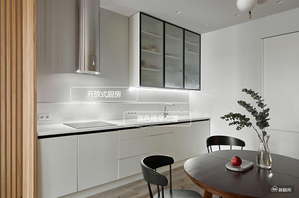 开放式厨房将餐厅与厨房一以贯之，打造空间的互动性和连贯性。
厨房延续客厅整体调性，白色硬装与白色软装搭配黑色点缀，饱含高级的精致感。
简约的白色收纳柜+灯带，从细微之处表达实用与舒适的生活理念。