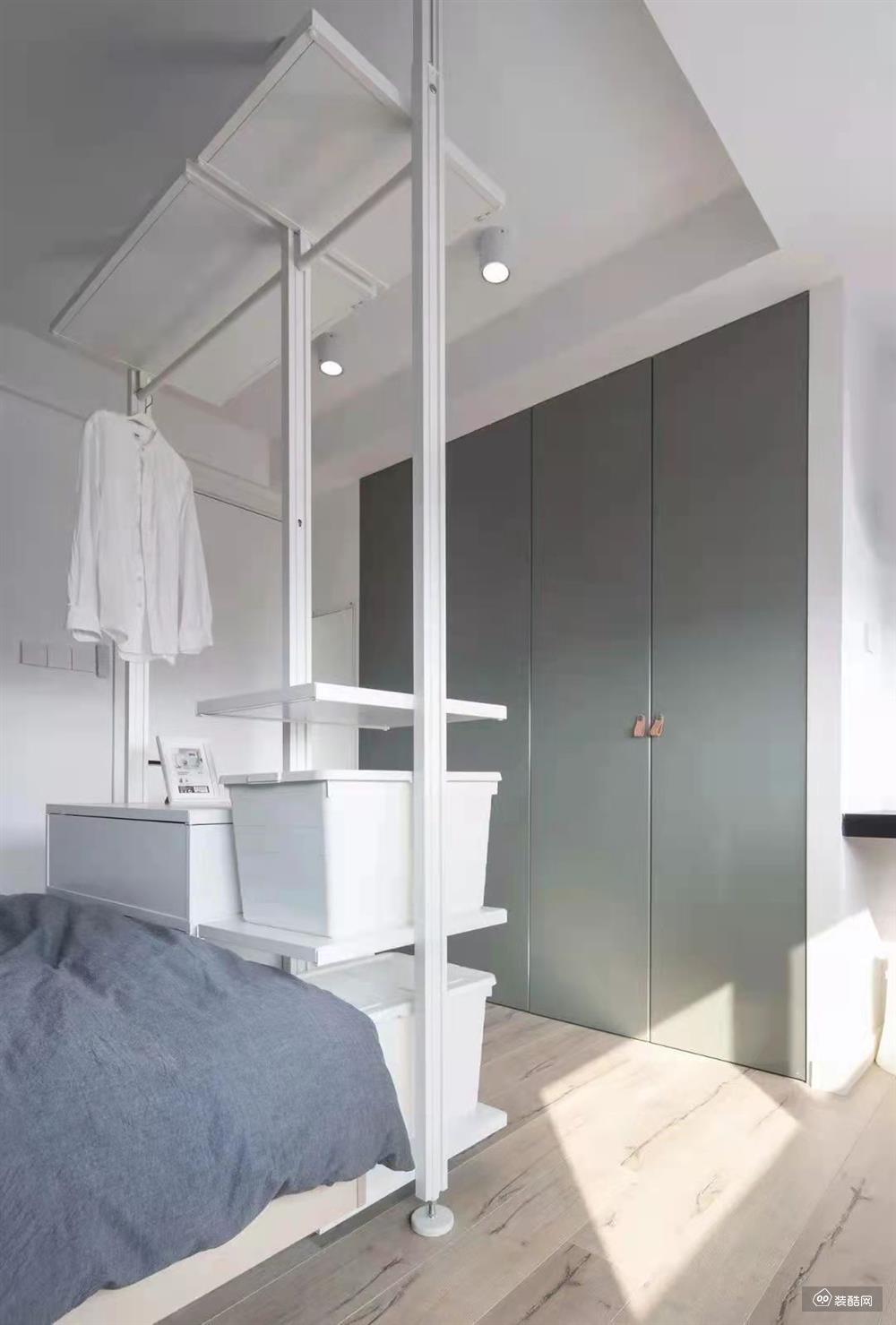 嵌入式衣柜的设计搭配床尾处的储物箱+衣架，满足了卧室衣物收纳的需求。