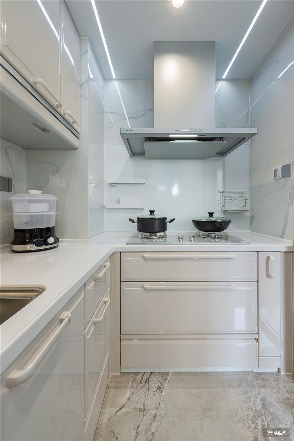厨房内部通透白色，打造出干净整洁的空间特质。上下方定制了白色亮面吊柜+地柜，储物性能直接拉满。纯色质感的橱柜与整体空间氛围保持一致，让人眼前一亮。