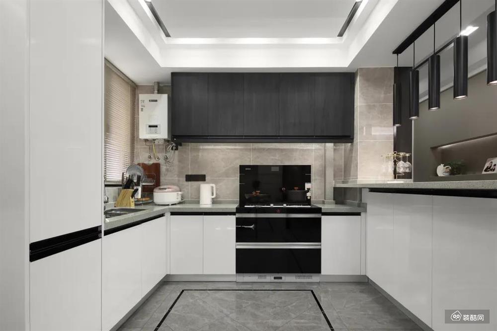 厨房设计成U型布局，并沿用黑白灰主调，打造出一个收纳力满满又简洁清爽的烹饪空间。