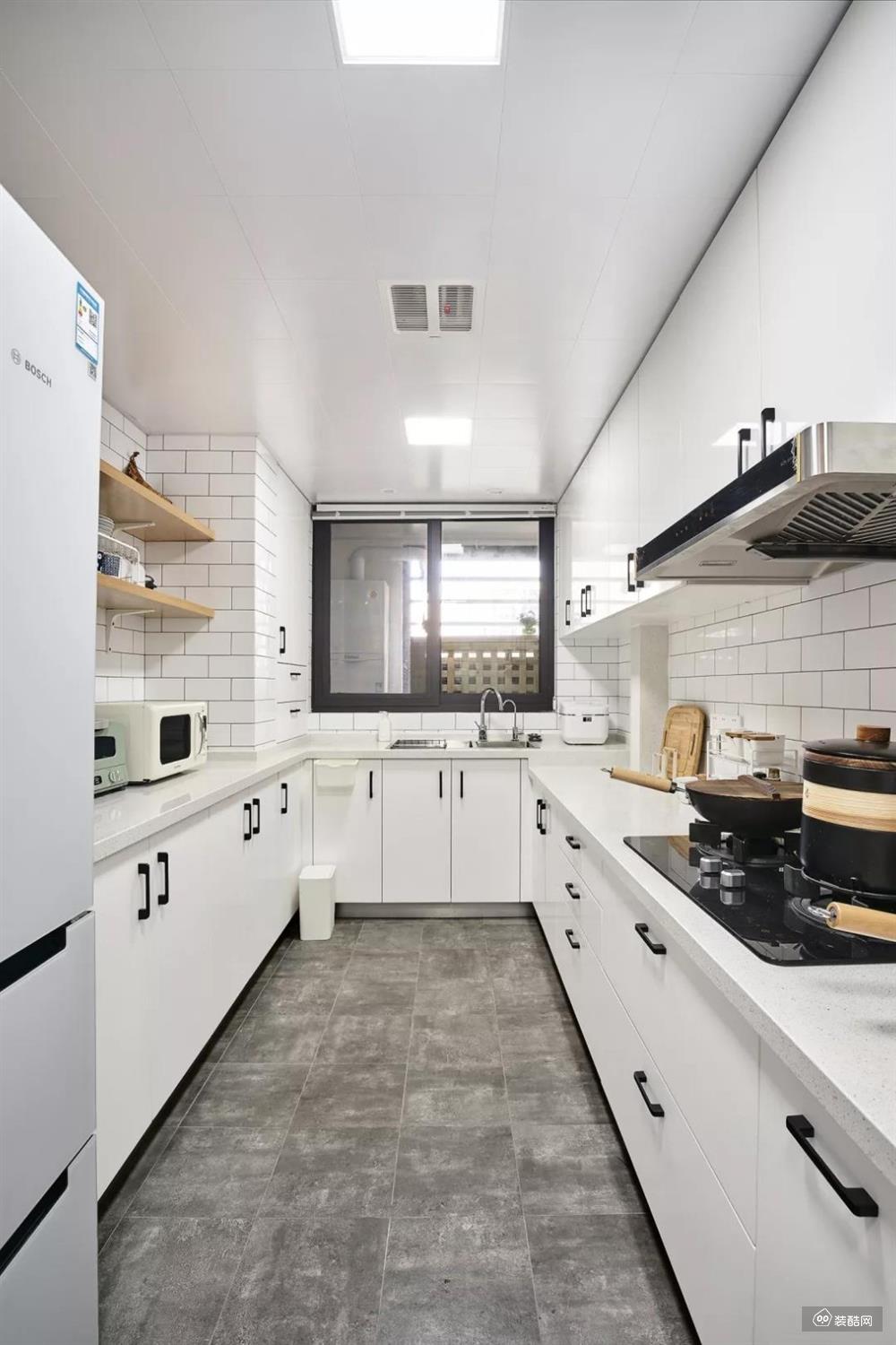 厨房内部的空间还是比较宽敞的，设计师选择了U字形的橱柜布局方案，让厨房动线变得更短，储物空间又更多，再加上白色与灰色的结合，简约而又轻松。