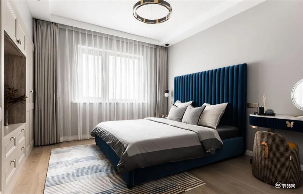 主卫在浅灰色的墙面基础，摆上一张深蓝色的布艺床、结合灰色的床单、窗帘、地毯，整个空间显得简约而静雅端庄。
