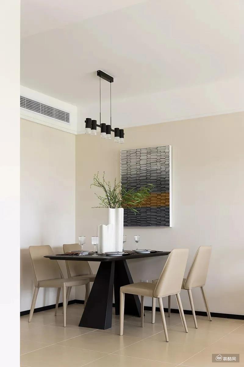 黑色的餐桌，搭配浅咖色的皮质餐椅，还有侧边独特的挂画。