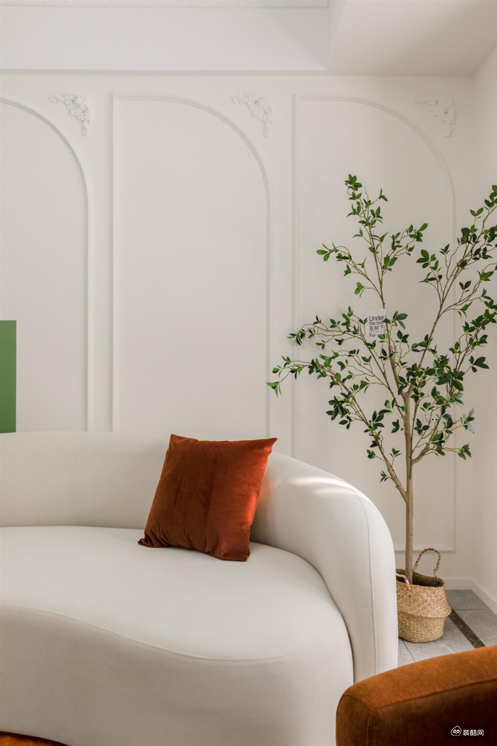 客厅用一系列的治愈色系，塑造出一个甜而不腻的童话空间。奶油色的沙发搭配焦糖色的抱枕和单椅，溢出满满的慵懒气息。角落的绿植，亭亭而立，赋予空间以生机。