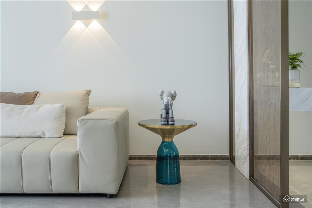 沙发墙是定制的大理石饰面与壁灯的结合，简约而有质感的空间氛围