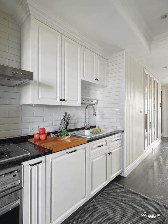 白色的仿砖设计让厨房具有怀旧复古的韵味，白色的橱柜与黑色的台面让空间看上去干净整洁。