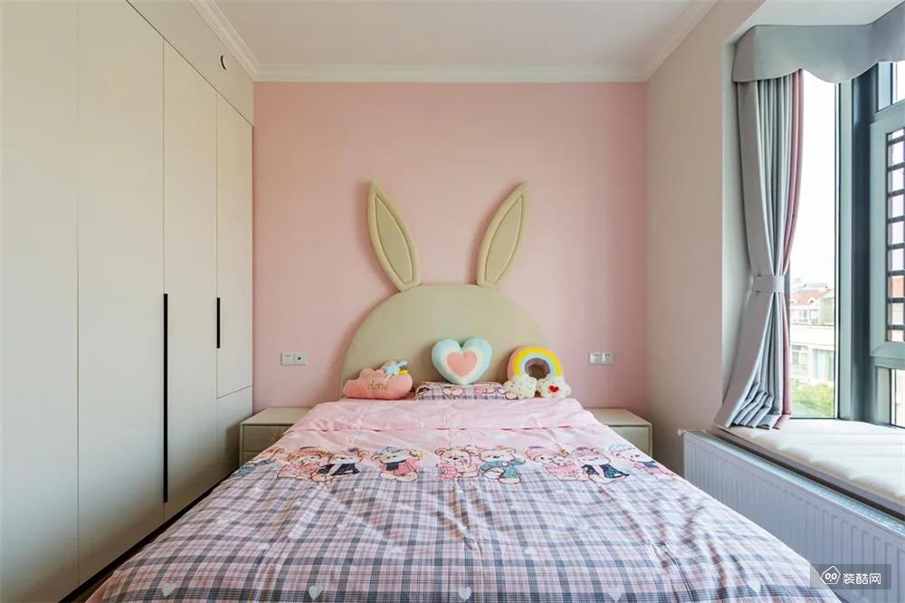 兔耳朵造型的软包床充满童趣，避免过多粉色的堆砌，只搭配床头粉色背景单面，侧面则打造嵌入式衣柜，搭配满足衣物的基础收纳。