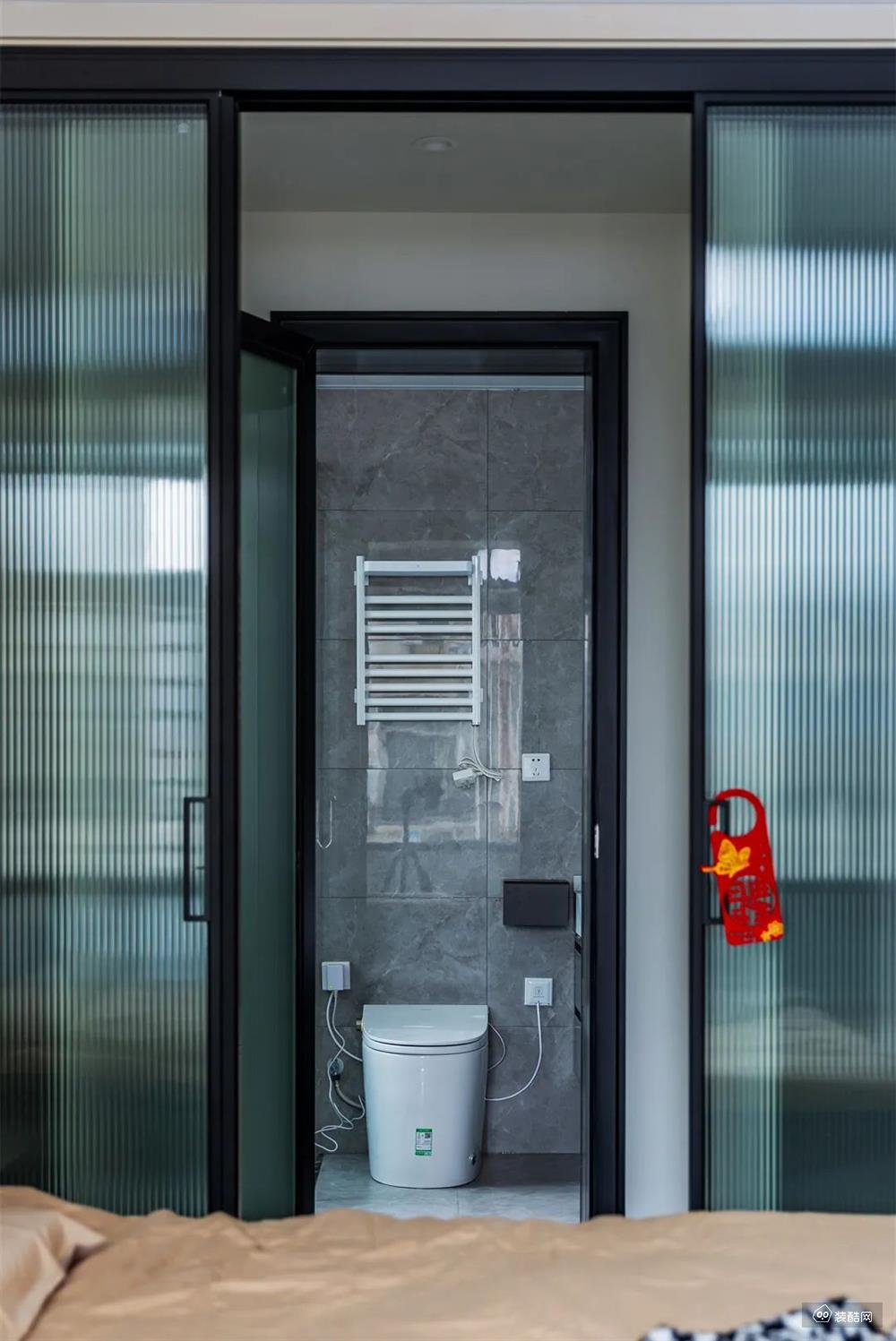 长虹玻璃移门分割开卫浴与休息区，形成了隔而不断的空间感，定制延长台盆柜+镜柜，大理石质感的空间令卫浴更加现代时尚。