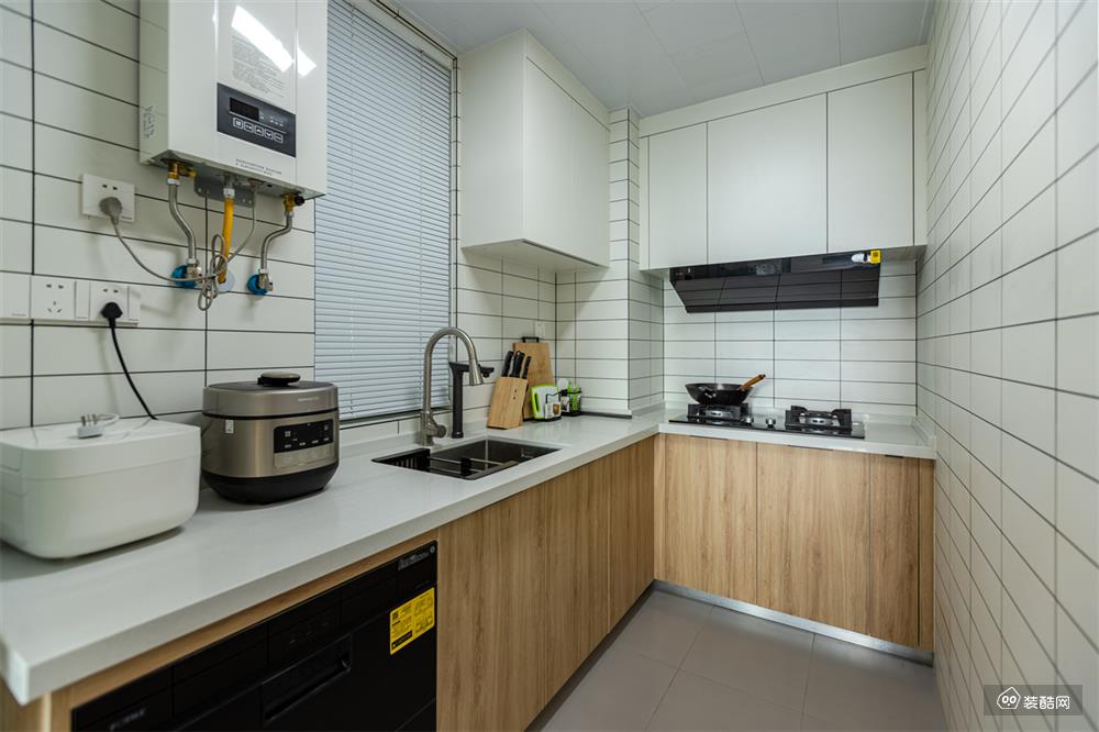 厨房面积相对紧凑，打造出U型厨房，更好地利用空间。各区分布合理，保持着流畅的烹饪动线。整个厨房墙面铺贴的是小白砖，搭配百叶帘和吊柜，层次分明又不显杂乱。