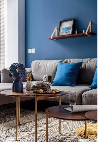 灰色转角沙发搭配蓝色背景墙,错落的层板用于装点背景与置物